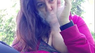 Nicoletta smokes in a public garden and shows you her big tits by pulling them out of her shirt